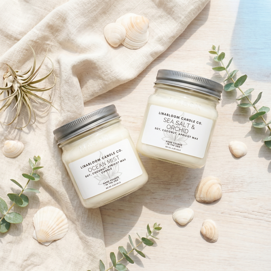 Lina Bloom Ocean Mist and Sea Salt & Orchid soy candles in a sunlit summer flat lay with shells and eucalyptus