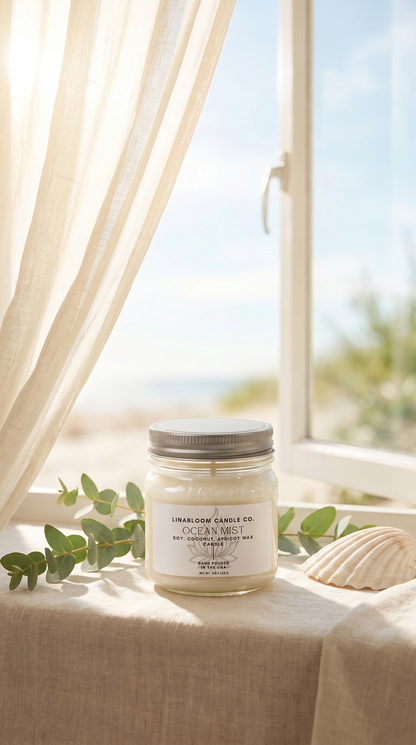 Lina Bloom Ocean Mist candle by an open window with a billowing sheer curtain and summer light