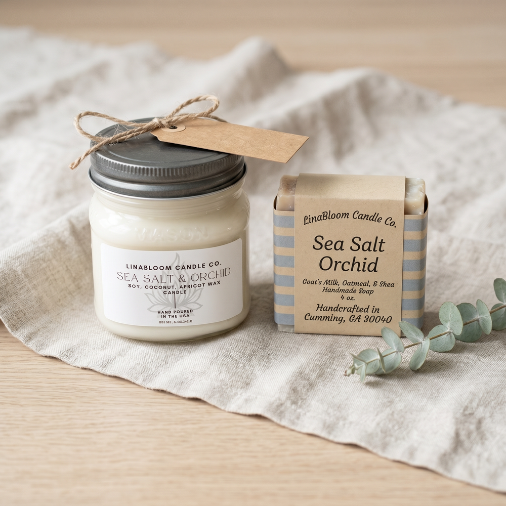 The Hostess Gift — LinaBloom Sea Salt & Orchid 8oz mason jar candle paired with matching kraft-striped Sea Salt Orchid bar soap on linen runner